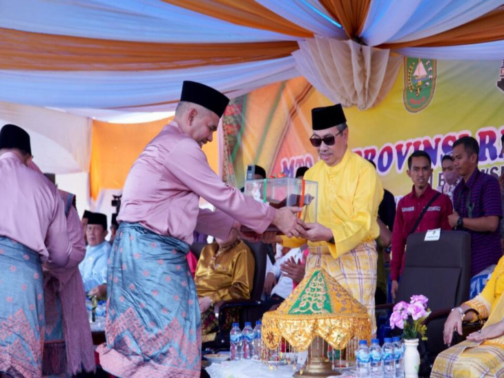 Usung Tigo Tungku Sajoangan, Pj Bupati Kampar Serahkan Rakal/Papan Tempat Baca Al-Qur’an dan Tasbih Kepada Gubernur pada Pawai Taaruf MTQ Ke-40.