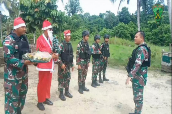 Satgas Pamtas Yonif 132/BS memberikan kejutan pohon natal dan nasi tumpeng kepada Mama dan Papa Papua